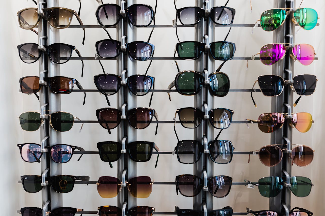 Services Variety of sunglasses displayed on racks in an indoor eyewear shop setting.